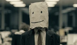 a banker with a bag over his head. the bag has a face on it