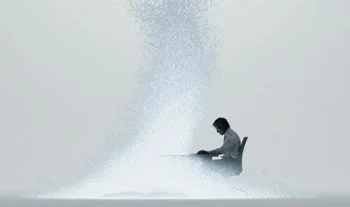 A man sitting at a desk with code rising up