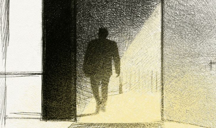 a man carrying a small bag walking into a well lit office 