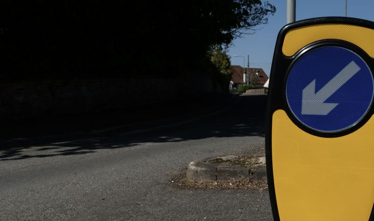 A British road with a sign and arrow 