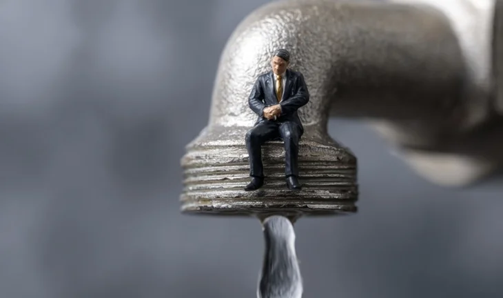 a small man by a tap 